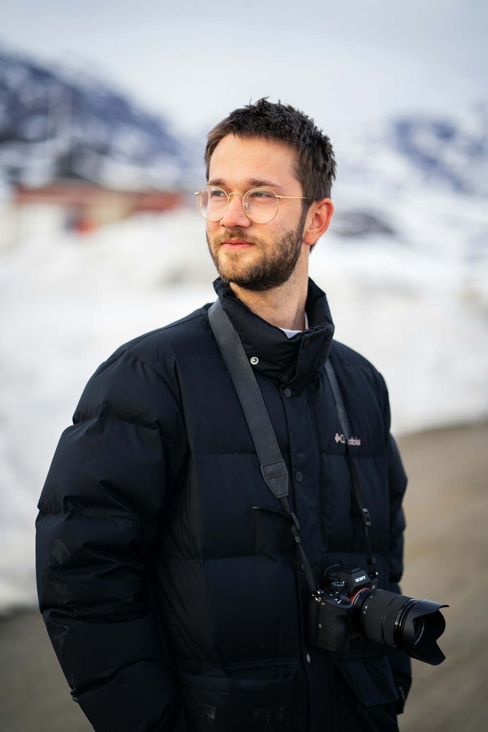 man in black jacket standing on snow covered ground during daytime