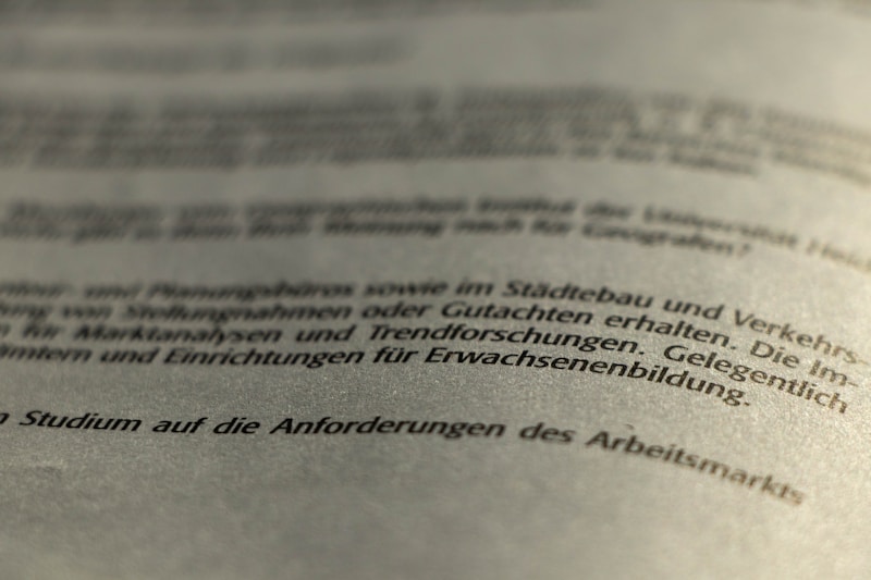 A close-up view of a printed German text, slightly blurred in the foreground and background, with a focus on the middle section. The document appears to be formal or academic in nature.