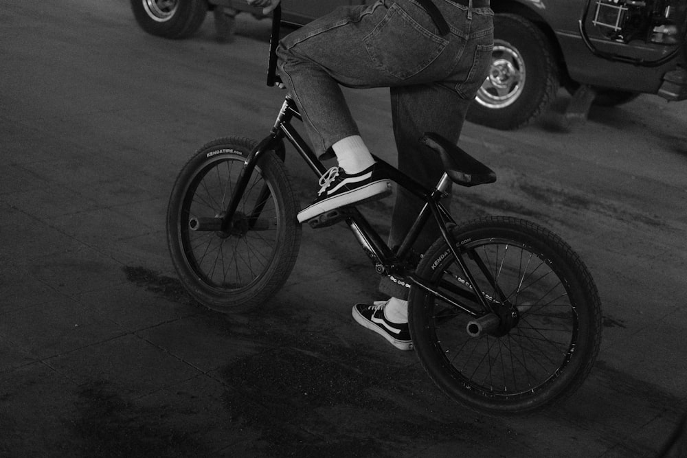 grayscale photo of man riding bicycle