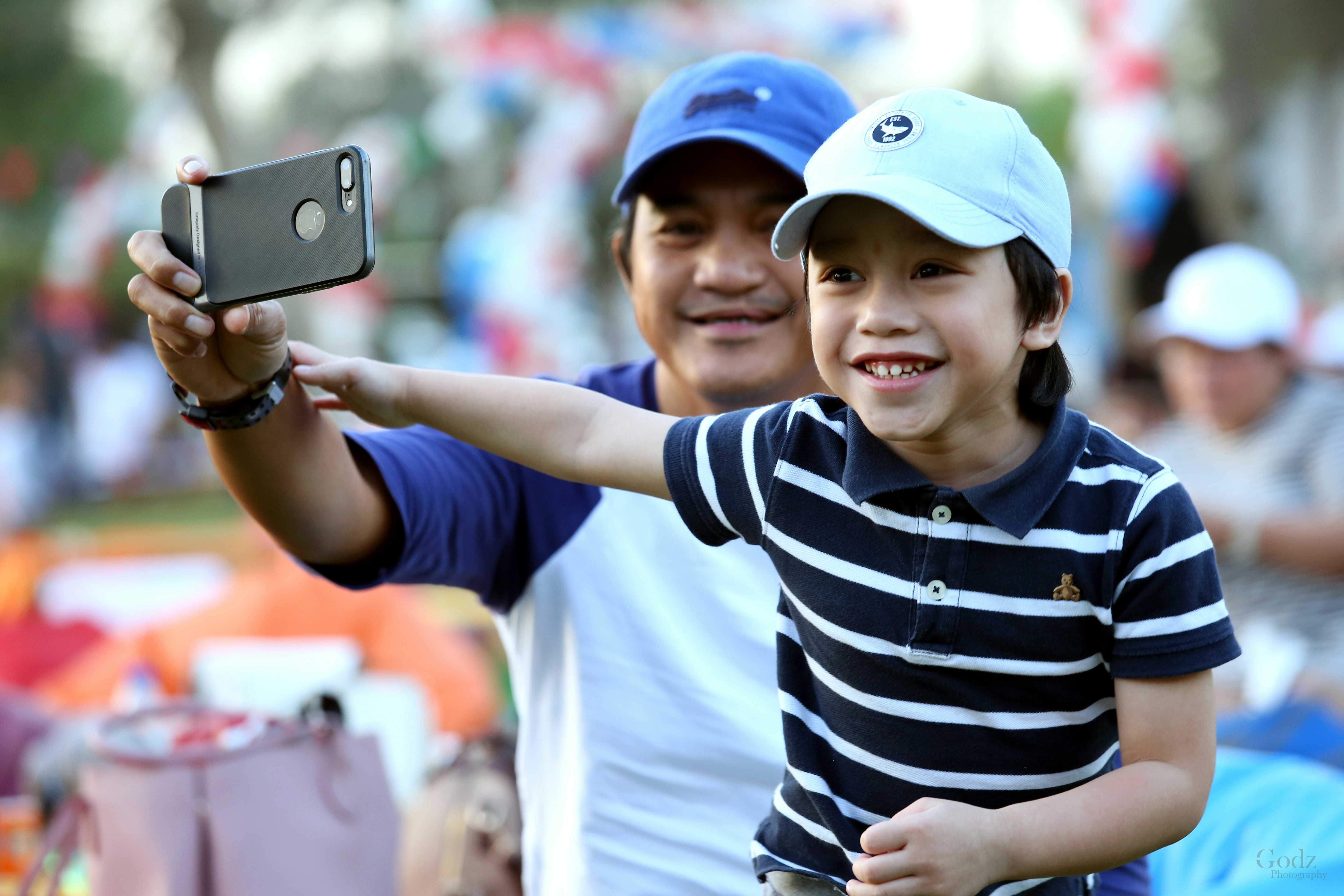 Junge in schwarz-weiß gestreiftem Poloshirt mit iPhone 6