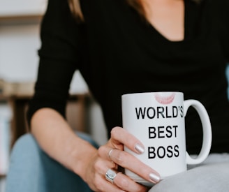 woman in black long sleeve shirt holding white ceramic mug