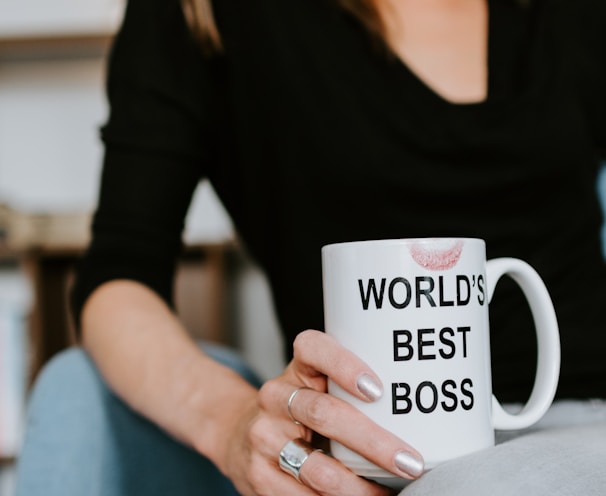 woman in black long sleeve shirt holding white ceramic mug