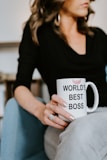 woman in black long sleeve shirt holding white ceramic mug