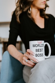 woman in black long sleeve shirt holding white ceramic mug