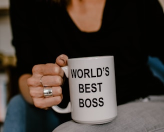 woman in black v neck shirt holding white ceramic mug