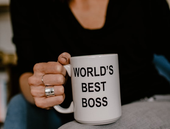 woman in black v neck shirt holding white ceramic mug