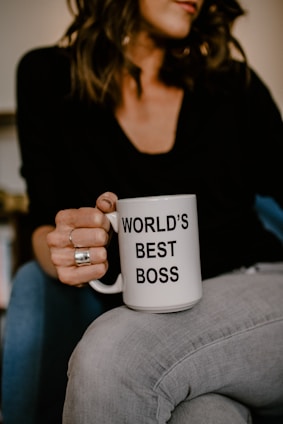 woman in black v neck shirt holding white ceramic mug