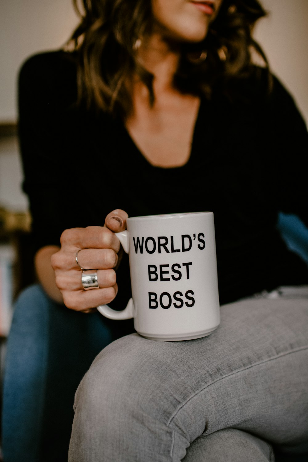 woman in black v neck shirt holding white ceramic mug