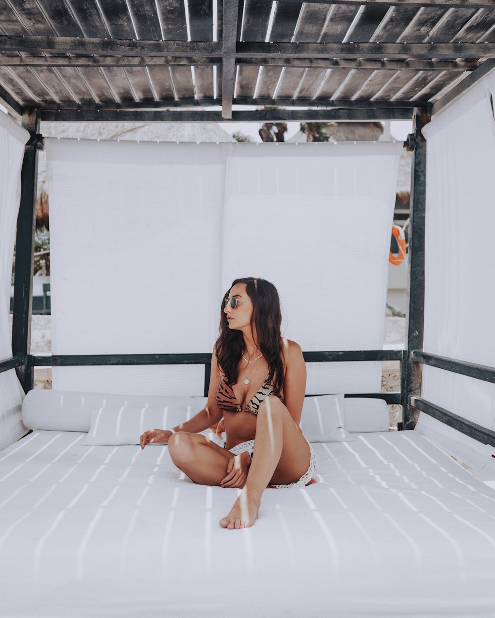 woman in brown bikini sitting on white bed