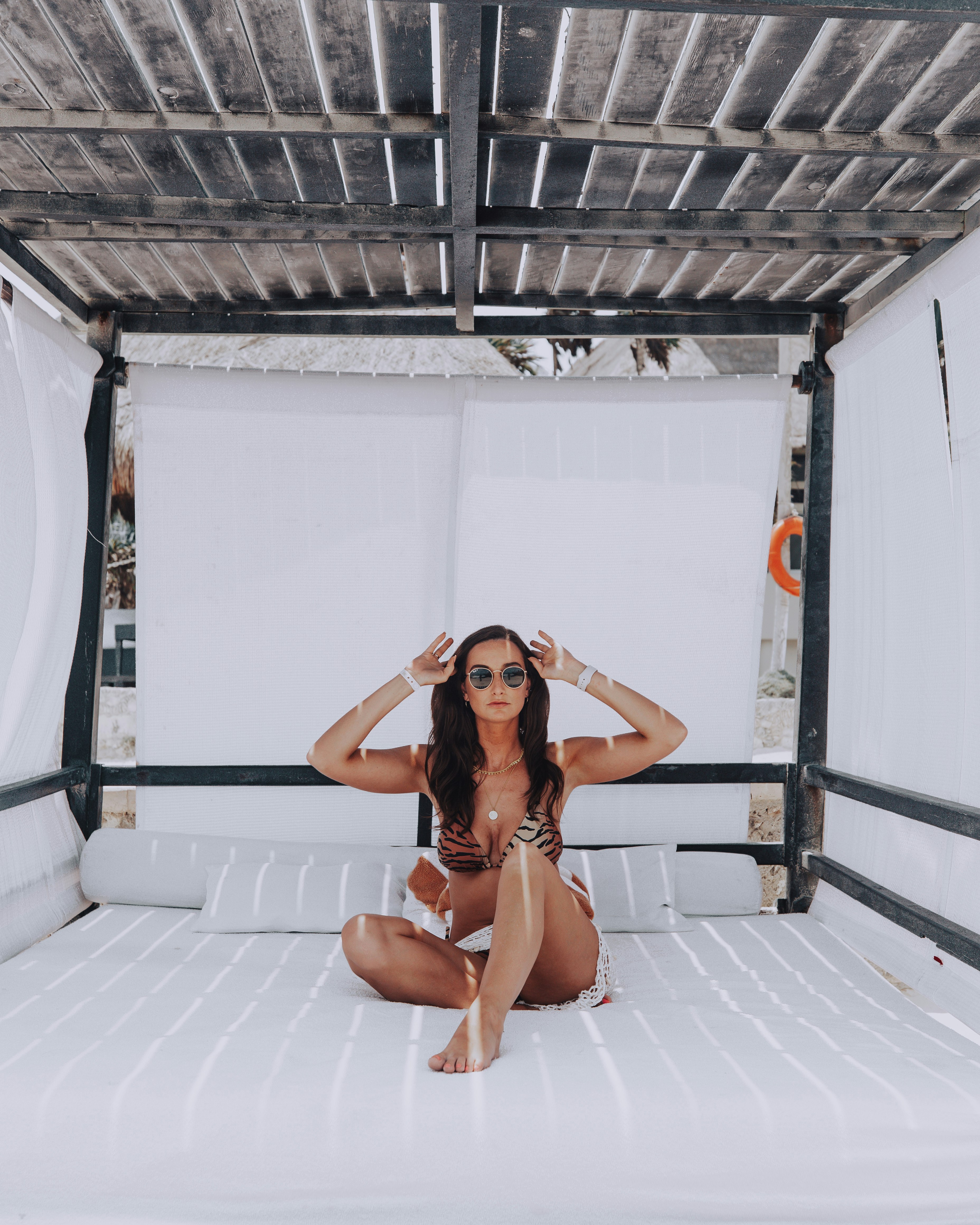 woman in black bikini sitting on white bed