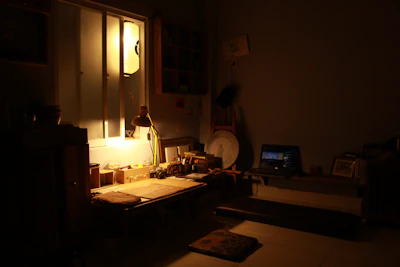 Softly lit room with art supplies and a laptop open to design software.