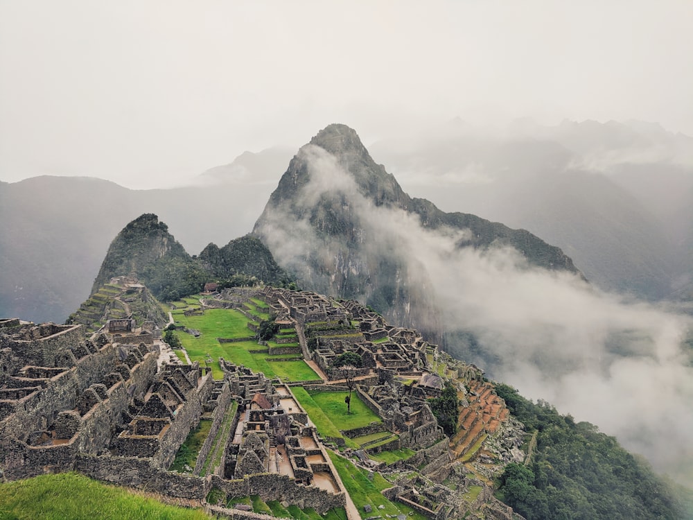 Montaña verde y negra bajo el cielo blanco durante el día