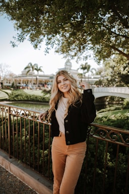 photography poses for women,how to photograph woman in black jacket and brown pants standing on bridge during daytime