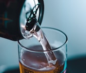 clear shot glass with brown liquid