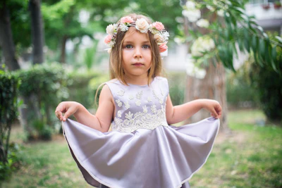 A little girl in a white dress with a flower crown