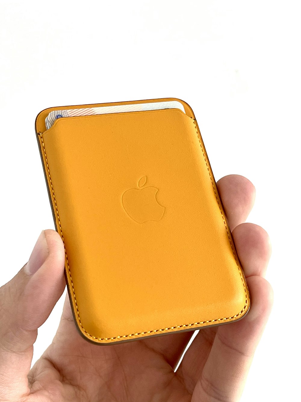 person holding gold apple iphone case