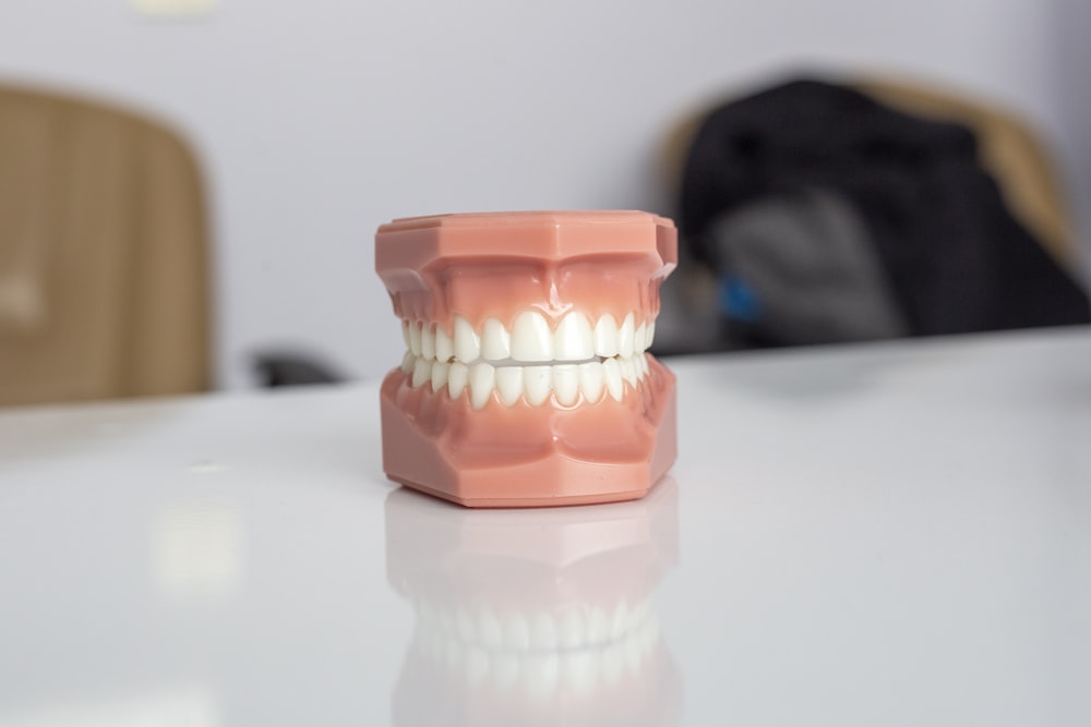 récipient en plastique orange sur une table blanche