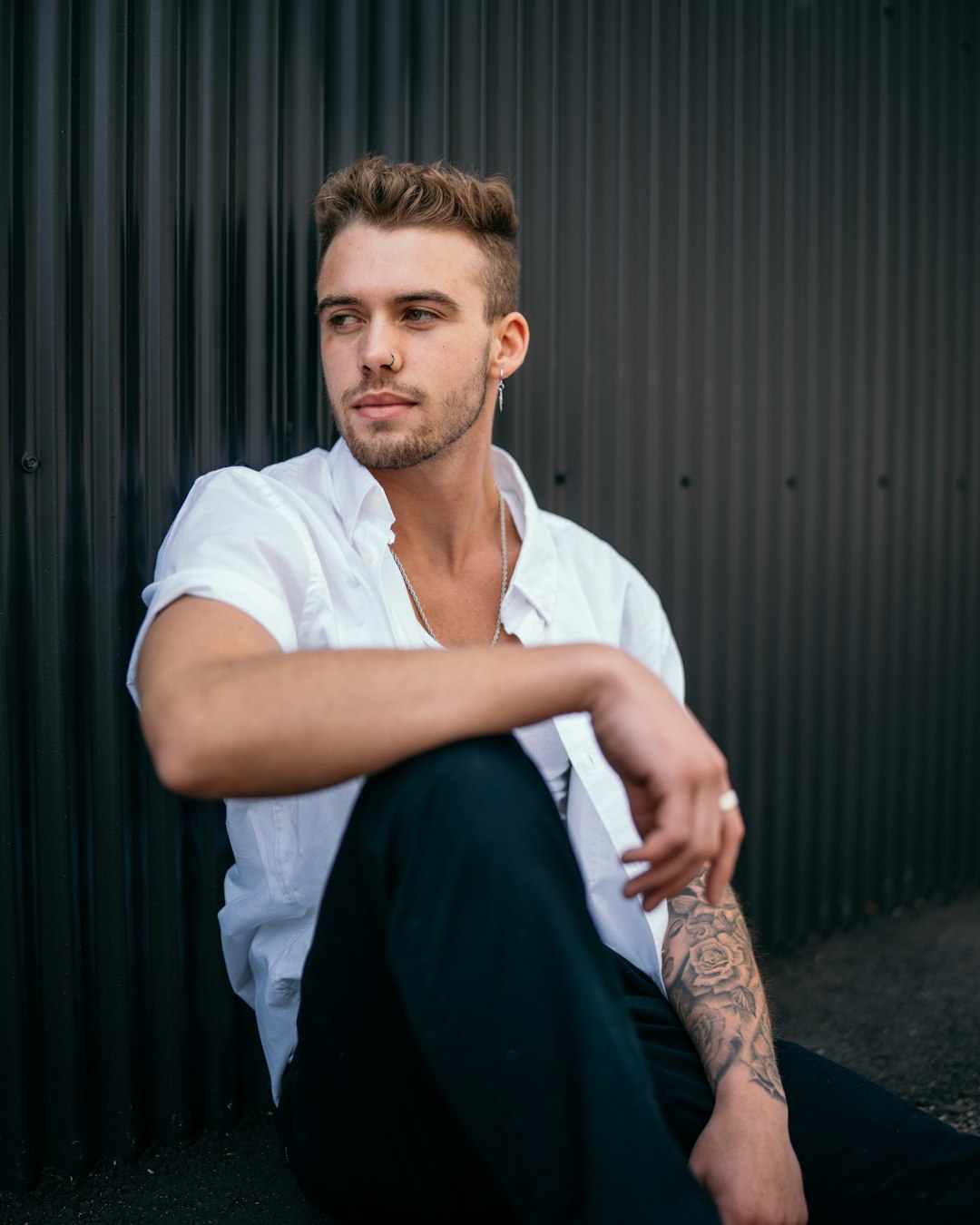 man in white crew neck t-shirt and black pants sitting on black chair