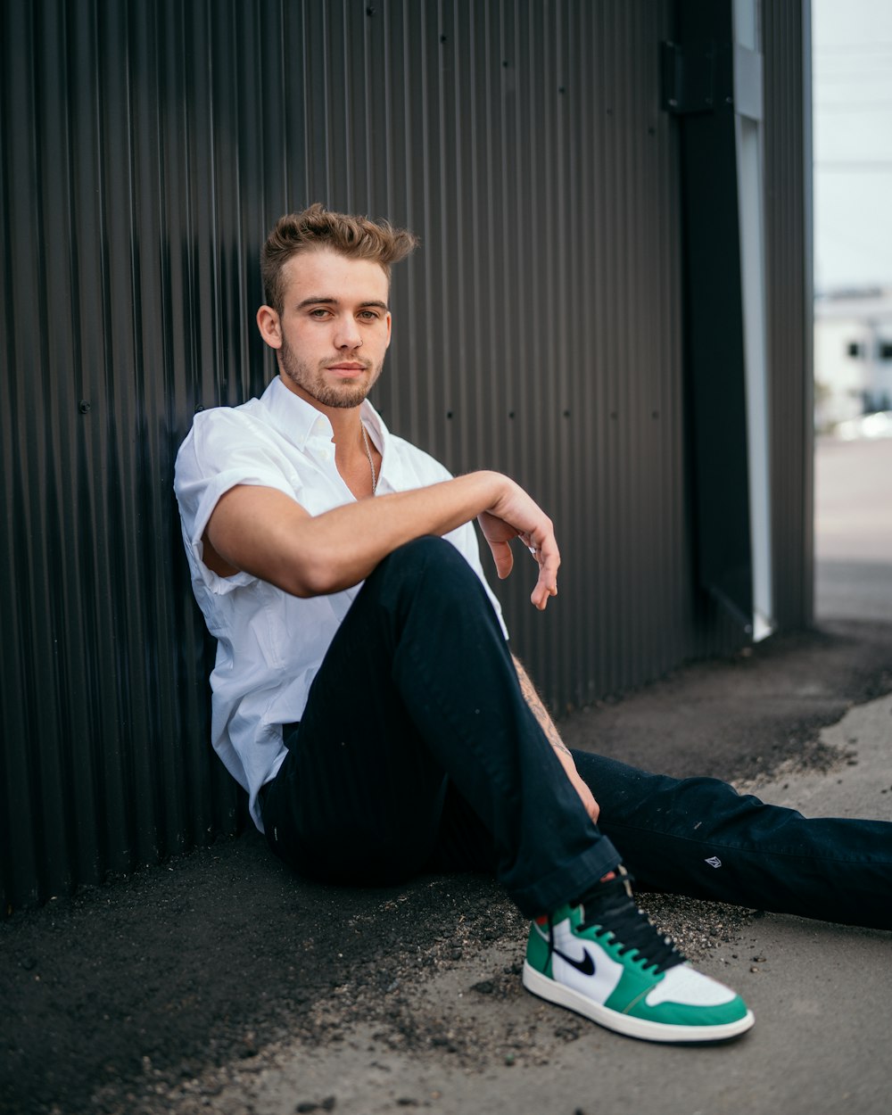 boy in white t-shirt and black pants sitting on floor