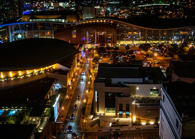 Wide-angle view of a bustling city street at night illuminated by sleek schön street lights casting crisp white light.