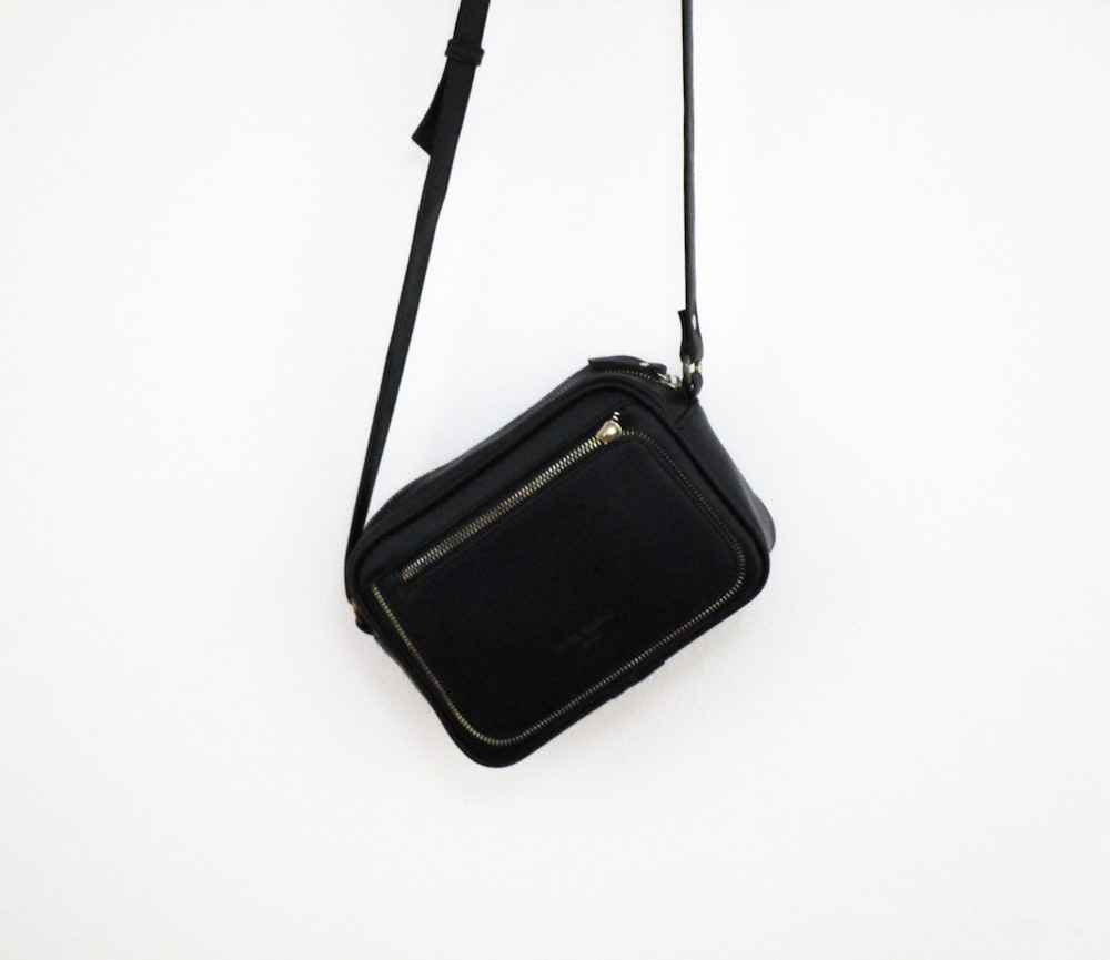 black sling bag on white surface