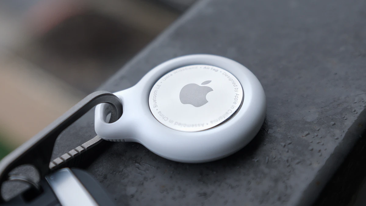 White silicone tracker holder clipped to a black bag strap