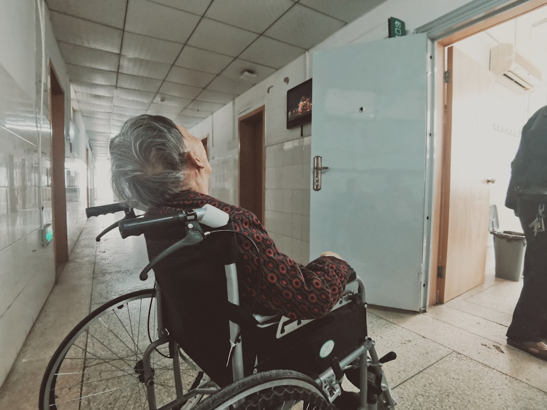 woman in black and white long sleeve shirt sitting on black wheelchair,