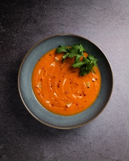 orange soup in black ceramic bowl