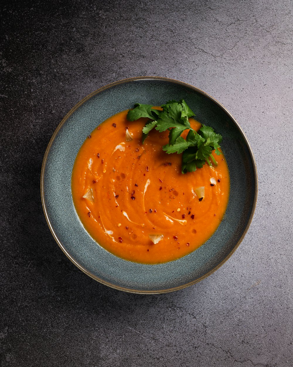 orange soup in black ceramic bowl