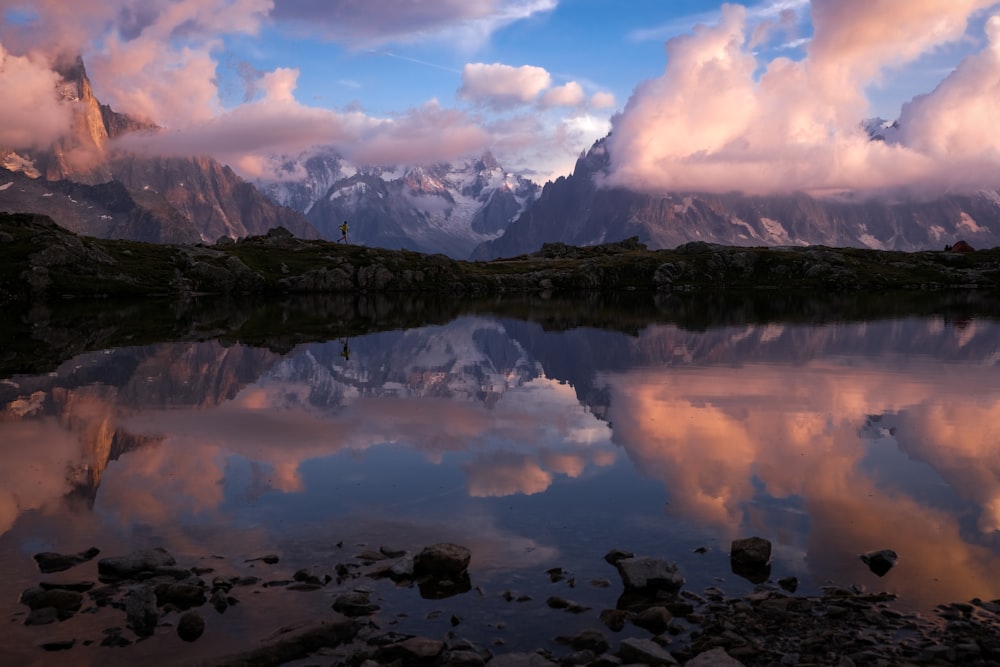 lake near trees and mountains under white clouds and blue sky during daytime