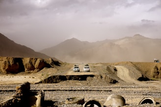 white and brown house on brown field near mountain during daytime