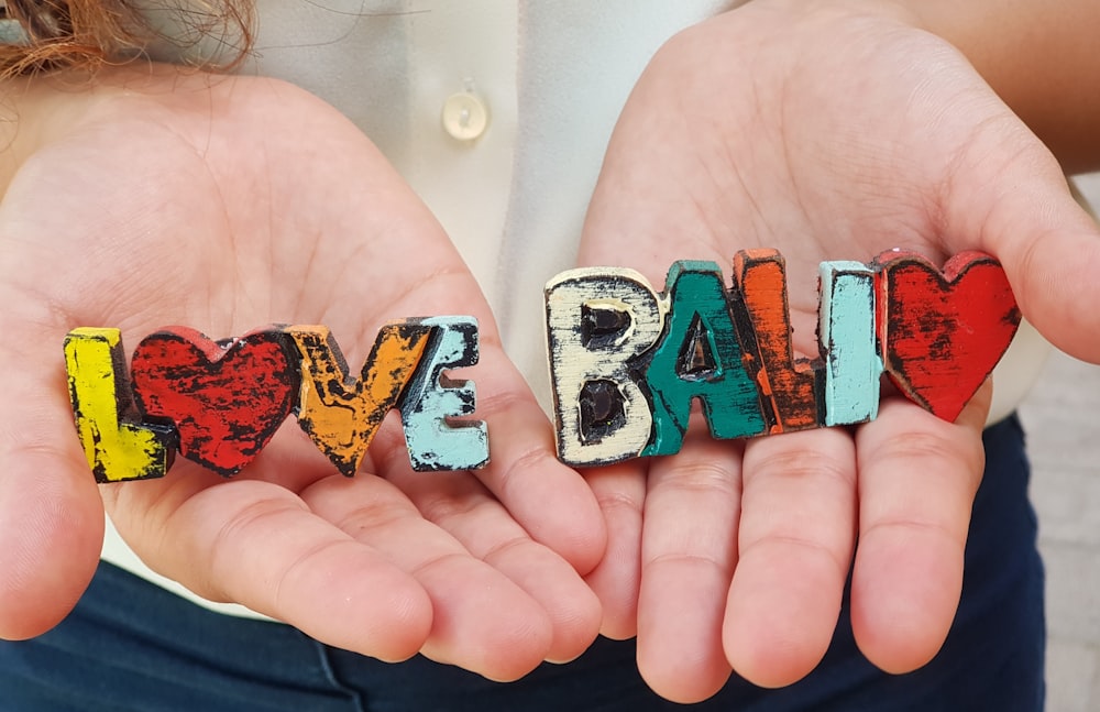 a pair of hands holding small letters spelling love and palm