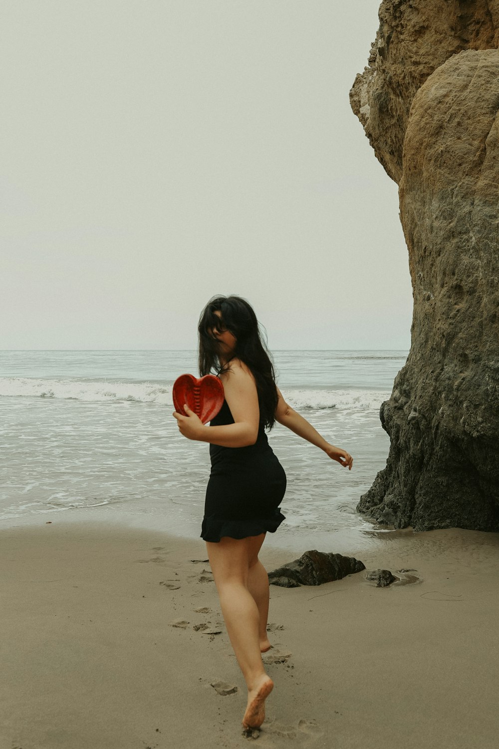 woman in black tank top and black shorts standing on beach shore during daytime