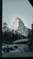 A cozy mountain lodge surrounded by snow-capped peaks.