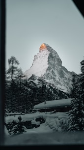 A cozy mountain lodge surrounded by snow-capped peaks.