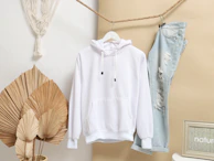 white zip up jacket hanging on brown wooden clothes hanger