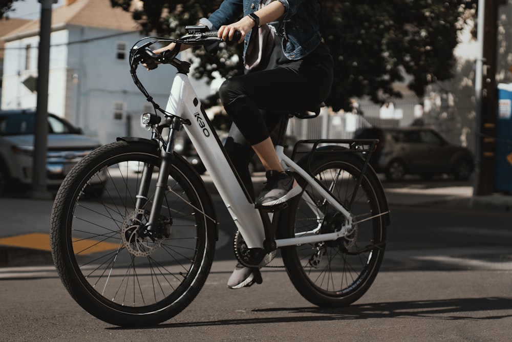 hombre en chaqueta negra montando en bicicleta blanca y negra