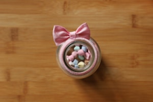 Brightly wrapped candy jars and party favors on a wooden surface