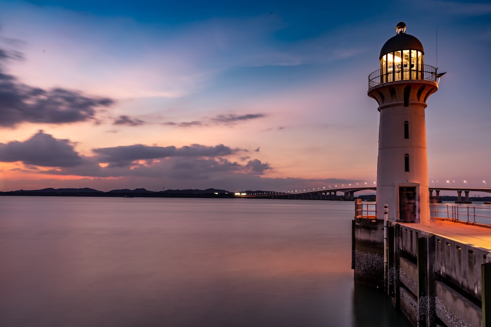 white and black lighthouse near body of water during daytime