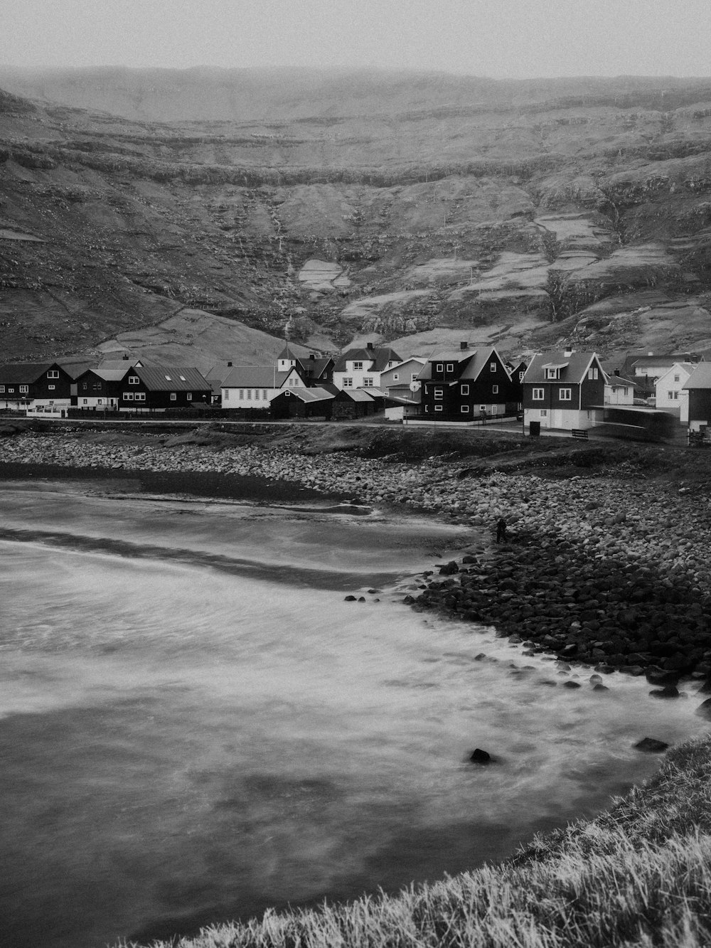 grayscale photo of houses near mountain