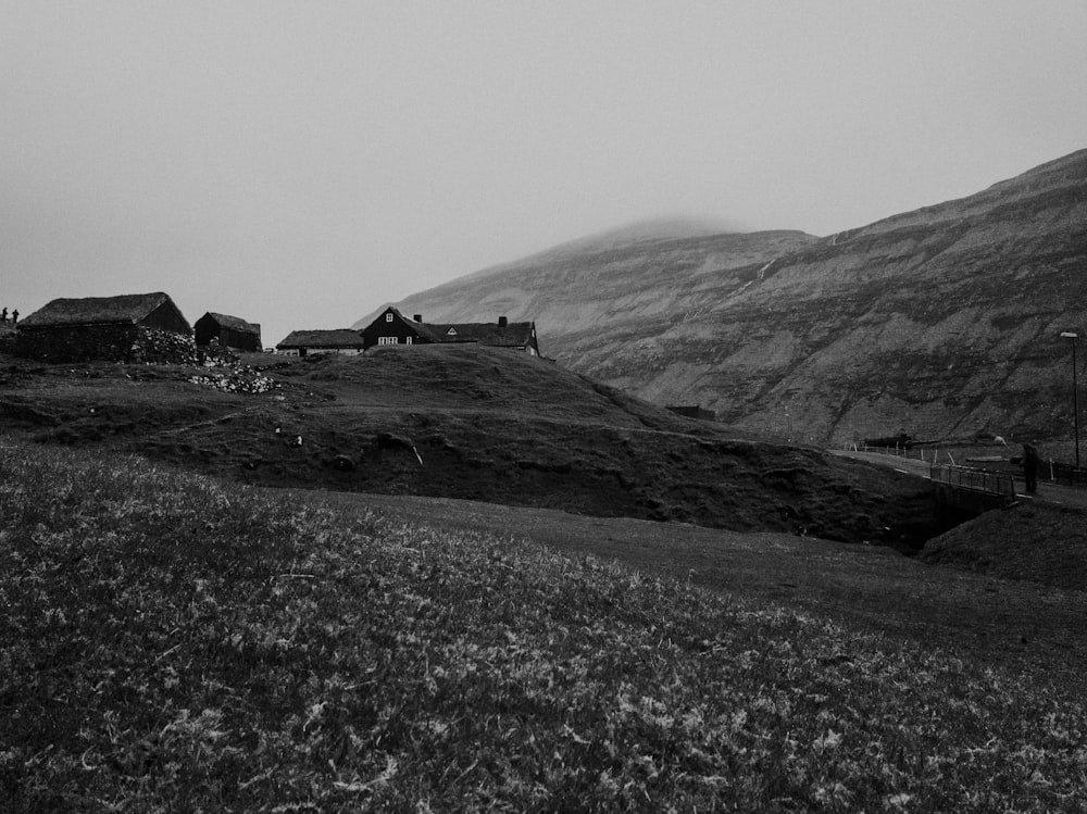 grayscale photo of house on hill