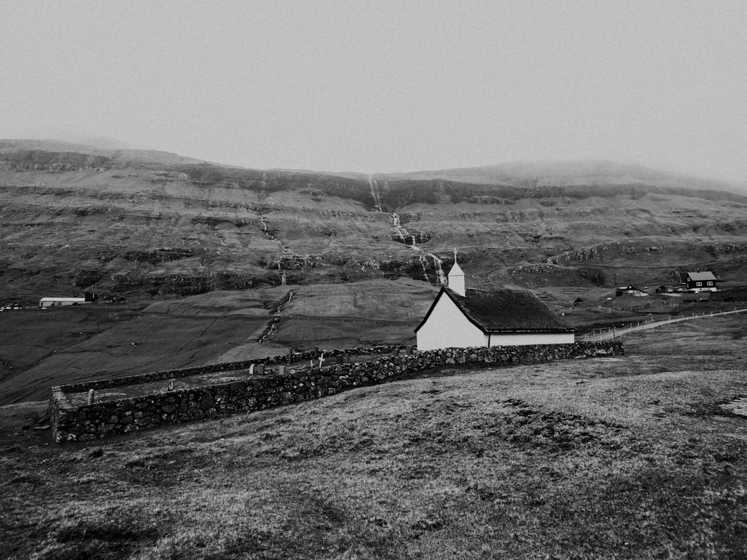 grayscale photo of a house on a hill