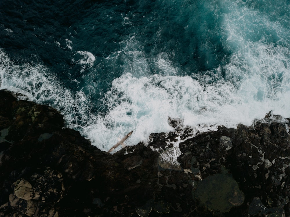 ocean waves crashing on rocks during daytime