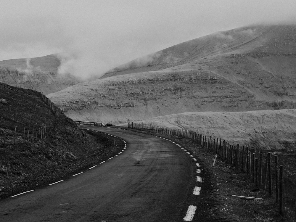 grayscale photo of road near mountain