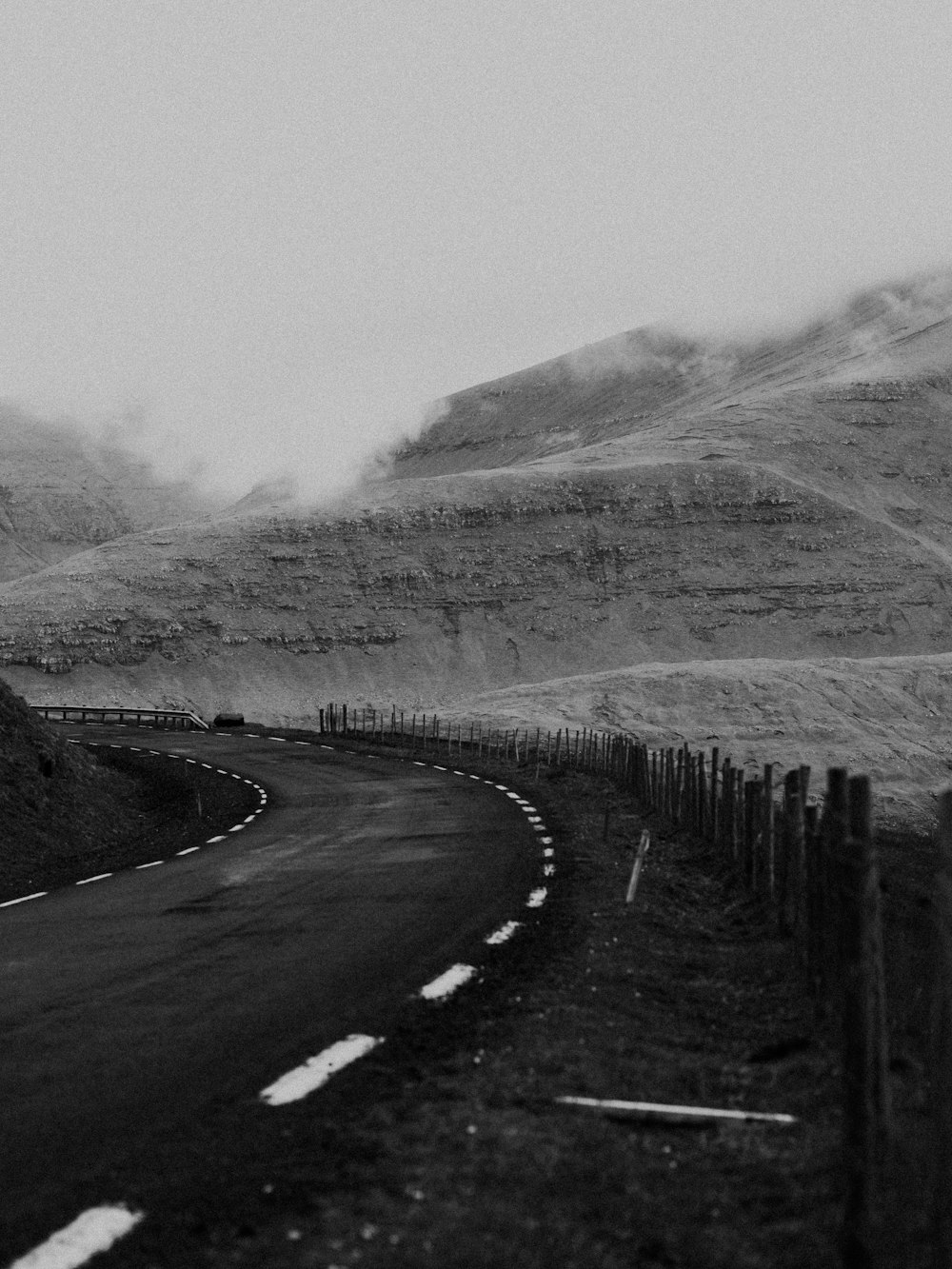 grayscale photo of road near mountain