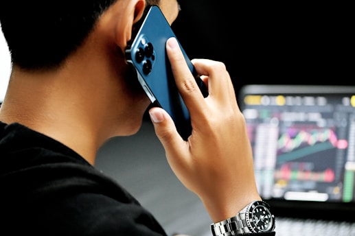 crypto compliance - man in black long sleeve shirt holding blue smartphone
