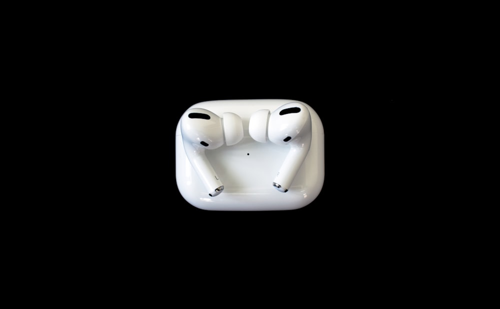 Auriculares de manzana blanca sobre superficie blanca