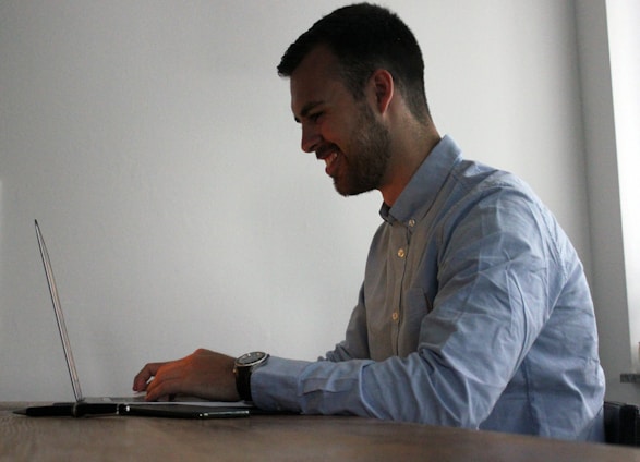 A happy person using a laptop at home, engaging with online tasks and earning rewards.