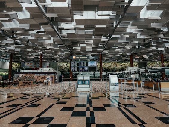 A friendly Flyaurra Airline customer service agent assisting a traveler at a modern airport counter.