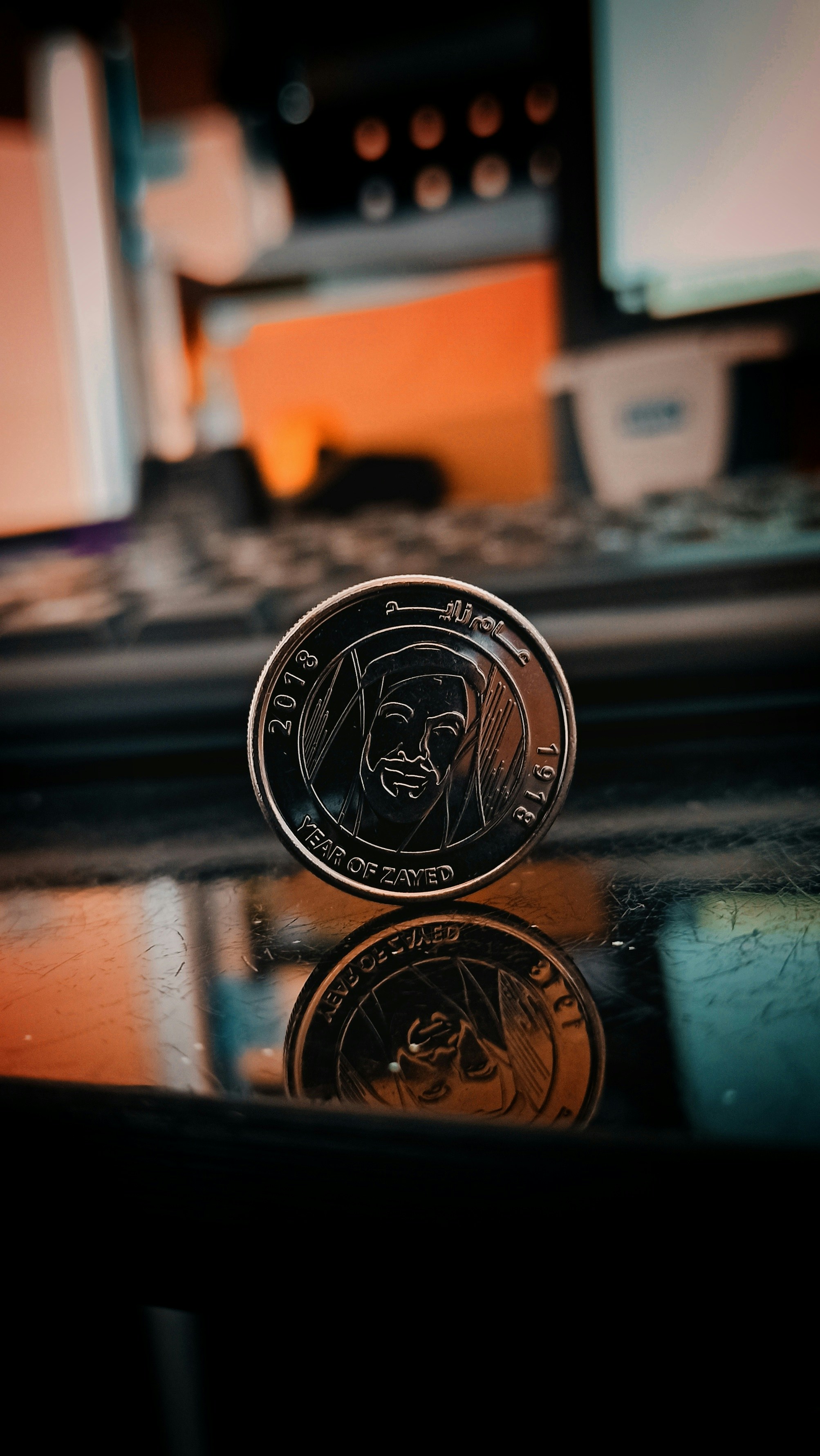 Silver South African Protea coin reflecting studio light on dark surface